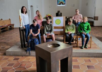 SchülerInnen der 6c und ihre Lehrerin vor dem Altar der Kirche und der Kulisse ihres Anspiels